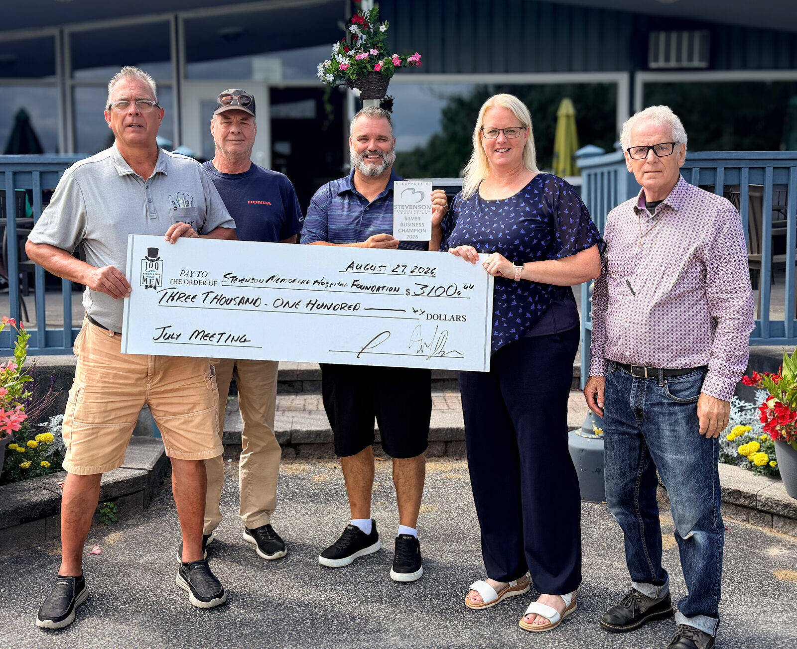 Fred Drodge and volunteers presenting a large donation cheque