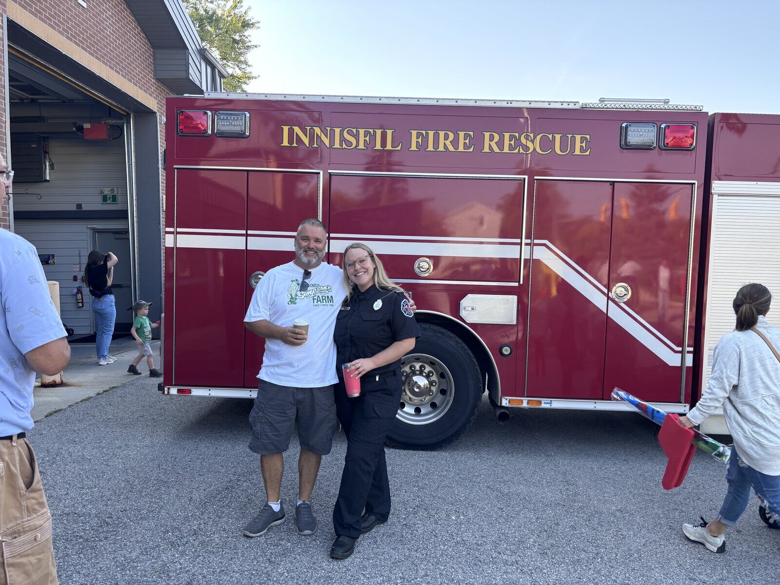 Fred Drodge with a firefighter in front of an Innisfil Fire Rescue truck