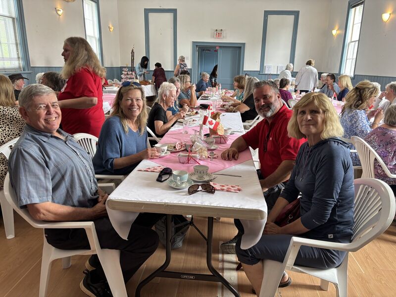 Residents seated at long tables for a community hall dinner