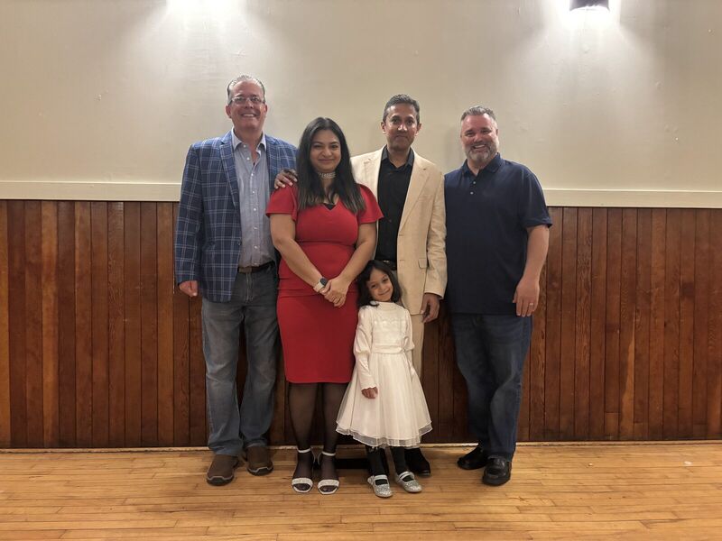 Fred Drodge with a family inside a community hall