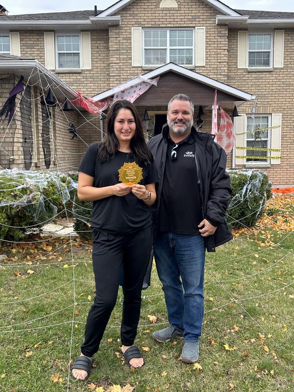 Fred Drodge and a woman in front of a house decorated for Halloween