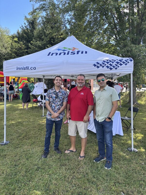 Fred Drodge with two men under a Town of Innisfil tent at an outdoor event